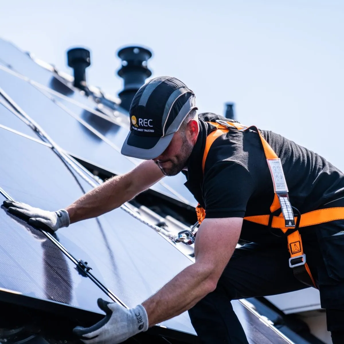 Solar Wave installer setting an REC panel on a rooftop