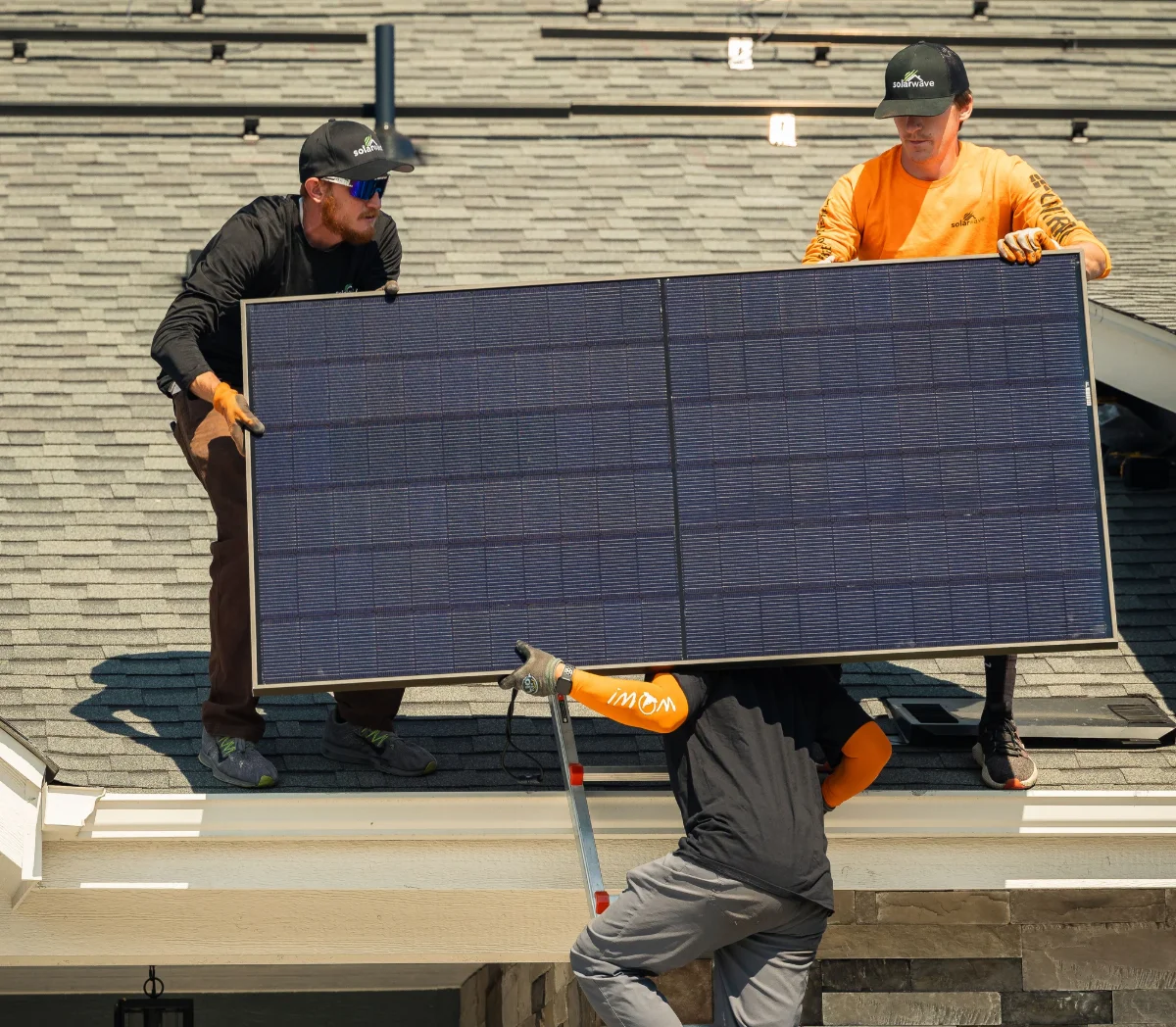 Solar Wave crew carefully removing a solar panel from a rooftop