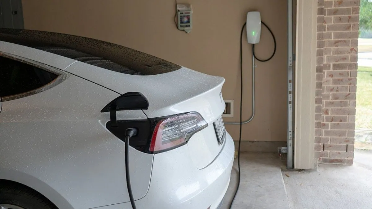 Tesla Wall Connector charging a white Tesla in a home garage